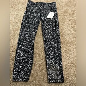 NWT Athleta ultimate stash 78 tight. Black and white pattern. Size medium.